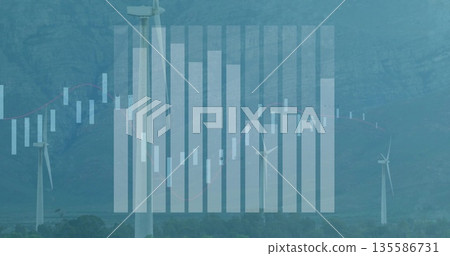 Towering white wind turbine rising in mountain valley, with financial charts overlay, copy space 135586731