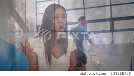 Reacting woman in white blouse at desk, staring at open laptop in office, with city skyline 135586798