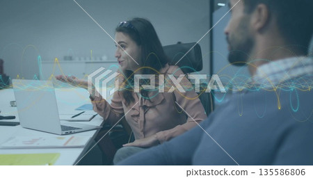 Speaking woman in pink blouse gesturing during office conference, with silver laptop and waveforms Speaking woman in pink blouse gesturing during office conference, with silver laptop and waveforms 135586806