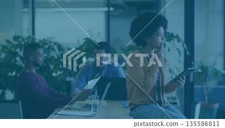 Holding tablet, African American woman gazing into distance at conference table, copy space 135586811