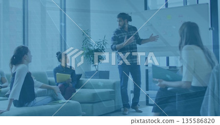 Presenting man in plaid shirt gesturing toward whiteboard in lounge, with sticky notes  and  noteboo 135586820