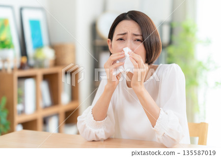 一位中年婦女在客廳擤鼻涕 135587019