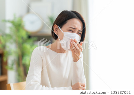一位中年婦女在客廳戴口罩 135587091