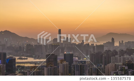 Jan 11 2026 Kowloon skyline and harbor under glowing orange sunset Jan 11 2026 Kowloon skyline and harbor under glowing orange sunset 135587578