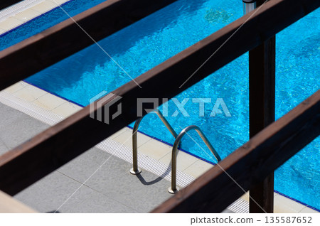 Top View of Pool Ladder in Clear Blue Water Top View of Pool Ladder in Clear Blue Water 135587652