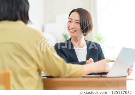 A businesswoman negotiating with another woman in the living room A businesswoman negotiating with another woman in the living room 135587673