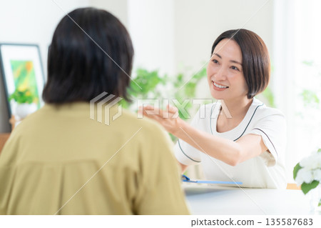 Female esthetician giving counseling Female esthetician giving counseling 135587683