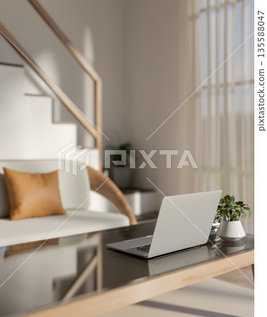 Laptop and pot plant on glass top wooden table and sofa beside stairs in living room of modern house Laptop and pot plant on glass top wooden table and sofa beside stairs in living room of modern house 135588047
