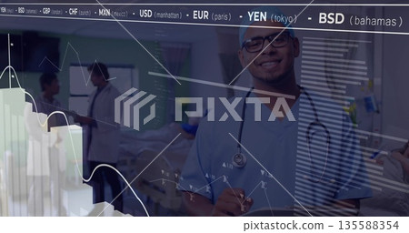 Smiling doctor in blue scrubs in hospital holding stethoscope with stock tickers overlay Smiling doctor in blue scrubs in hospital holding stethoscope with stock tickers overlay 135588354