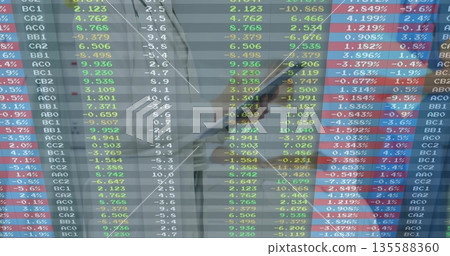 Monitoring businesswoman in office tracking stock tickers on trading screen, with smartphone 135588360