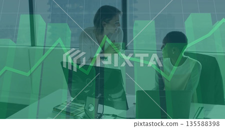 Collaborating female colleagues in business attire analyzing charts in office, with coffee mug Collaborating female colleagues in business attire analyzing charts in office, with coffee mug 135588398