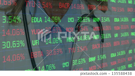 Merging clinician in blue scrubs at hospital amid stock ticker overlay, with stethoscope 135588438