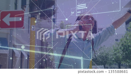 Standing male student wearing blue shirt and backpack on city street corner, with digital overlay 135588681