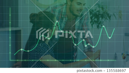 Man in plaid shirt leaning over woman reviewing data on office computer, with green graph overlay Man in plaid shirt leaning over woman reviewing data on office computer, with green graph overlay 135588697