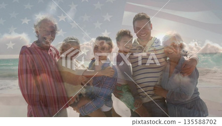 Embracing multi-generational family members holding children on sandy shore, with patterned trunks Embracing multi-generational family members holding children on sandy shore, with patterned trunks 135588702