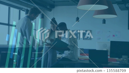 Three colleagues reviewing documents at high table in modern office, with tablet and data overlays 135588709