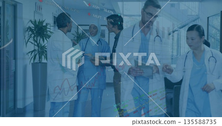 Reviewing medical charts five medical professionals walking hospital corridor, with digital overlay Reviewing medical charts five medical professionals walking hospital corridor, with digital overlay 135588735