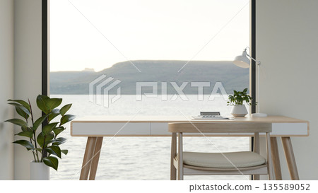 Calculator and pot plant aside lamp on wooden table with outside scenery through glass window wall. 135589052