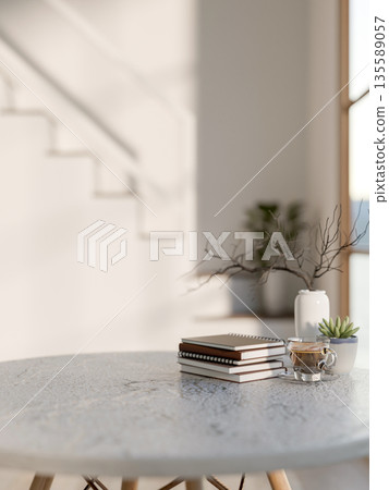 Notebooks and coffee cup aside pot plant and vase on marble table and white stars in a modern house. Notebooks and coffee cup aside pot plant and vase on marble table and white stars in a modern house. 135589057
