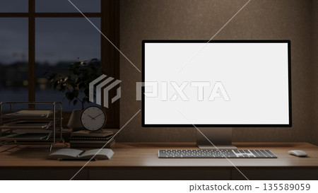 White screen computer and clock atop books on wooden table under window in a dim lit room. White screen computer and clock atop books on wooden table under window in a dim lit room. 135589059