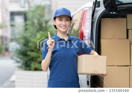 Middle-aged female delivery person delivering packages by car 135589160