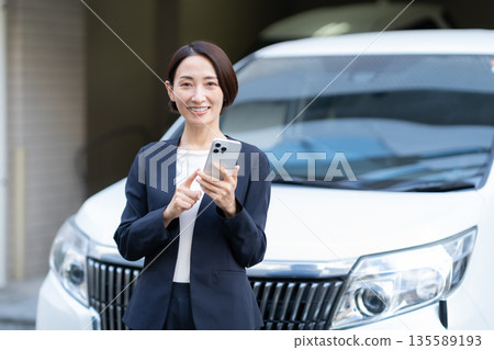 A middle-aged businesswoman working in a car 135589193