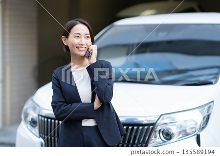 A middle-aged businesswoman working in a car A middle-aged businesswoman working in a car 135589194