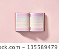 Open notebook with lined pages lying on a pink background created for note-taking or journaling in a study space 135589479