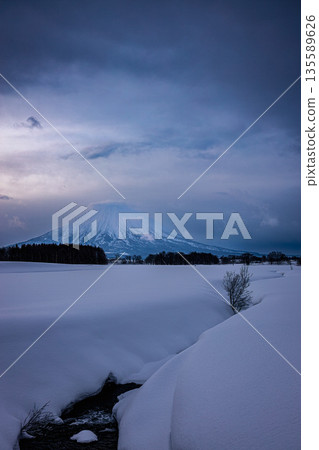 Mount Yotei towering over the snowy fields: Winter scenery in Kutchan, Hokkaido 135589626