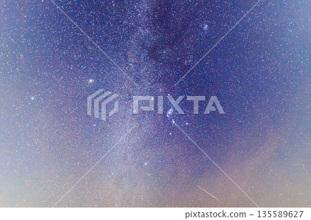 A meteor appears in the Milky Way and starry night sky 135589627