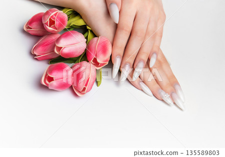 Elegant woman hands with long white manicure nails Elegant woman hands with long white manicure nails 135589803
