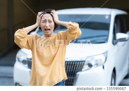 A middle-aged woman in trouble because her car broke down A middle-aged woman in trouble because her car broke down 135590087