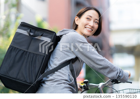 A woman delivering food by bicycle 135590110