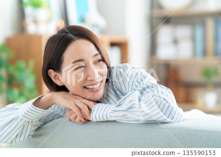 中年婦女在客廳的沙發上放鬆 135590153