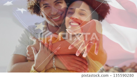 Hugging couple showcasing engagement ring on rocky shoreline at sunset, with flag overlay Hugging couple showcasing engagement ring on rocky shoreline at sunset, with flag overlay 135590280