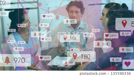 Brainstorming business team collaborating around table in meeting room with floating visuals 135590336