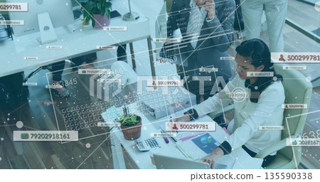 Collaborating three businesswomen reviewing charts and typing on laptops in office, with smartphone Collaborating three businesswomen reviewing charts and typing on laptops in office, with smartphone 135590338