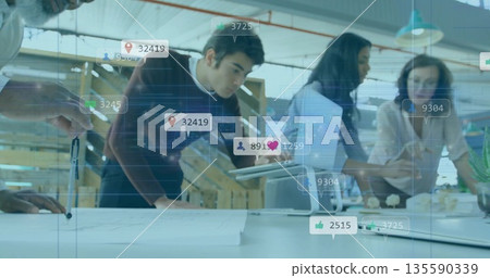 Gesturing professionals examining plans with tablet in open-plan office, with floating icons Gesturing professionals examining plans with tablet in open-plan office, with floating icons 135590339