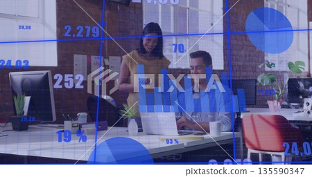 Data professionals in business attire reviewing data using laptop and monitors at office 135590347