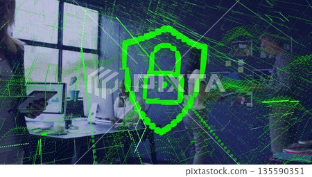 Displaying green shield lock overlay above coworkers using laptops and monitors in modern office 135590351