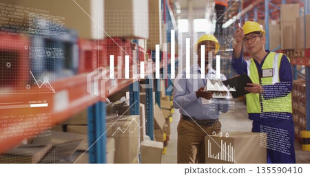 Two men wearing safety helmets reviewing data overlays in warehouse aisle, with tablet clipboard Two men wearing safety helmets reviewing data overlays in warehouse aisle, with tablet clipboard 135590410