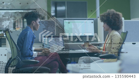Chatting woman and coworker typing laptop and holding coffee cup at office near dividers Chatting woman and coworker typing laptop and holding coffee cup at office near dividers 135590443