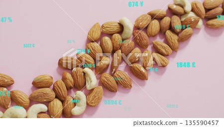 Displaying diagonal band of almonds and cashews on pale pink surface, with turquoise digital labels 135590457