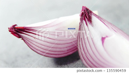 Showcasing close-up of two red onion halves on kitchen countertop, showing vibrant purple rings 135590459