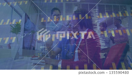 Analyzing financial data, team lead in red blazer pointing at monitor with colleagues in office 135590480