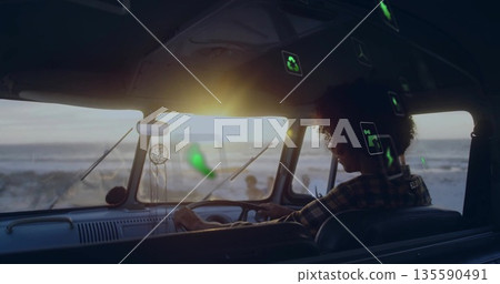 Steering man in green plaid shirt driving camper van on coastal road with dreamcatcher, copy space Steering man in green plaid shirt driving camper van on coastal road with dreamcatcher, copy space 135590491