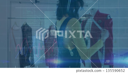 Inspecting Asian woman examining red jacket in boutique, with rack, graph overlay and headset Inspecting Asian woman examining red jacket in boutique, with rack, graph overlay and headset 135590652