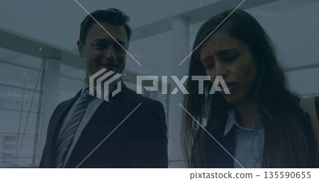 Sharing worried looks coworkers wearing suit in airport lobby with shoulder bag and gate 135590655