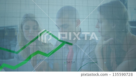 Three colleagues in office wear analyzing financial data at table, with laptop and chart overlay 135590728