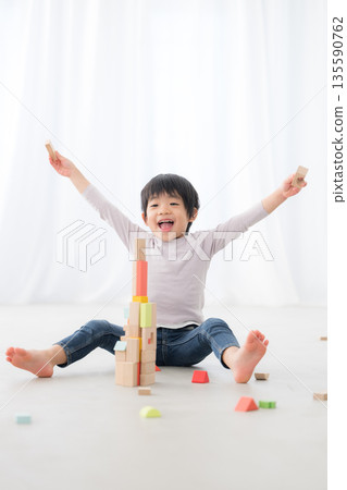 一個男孩精力充沛地玩積木。耶，我做到了！這張圖展現了非認知能力，即透過堅持不懈取得成就和成功。 135590762